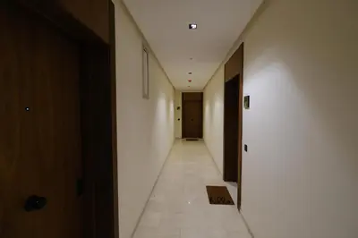 a hallway with white walls and a long hallway with doors at Appartement chic et cosy - Casablanca Finance City in Casablanca
