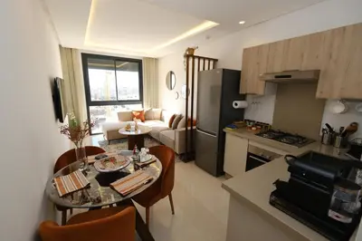 a kitchen and a living room with a table in a kitchen at Appartement chic et cosy - Casablanca Finance City in Casablanca