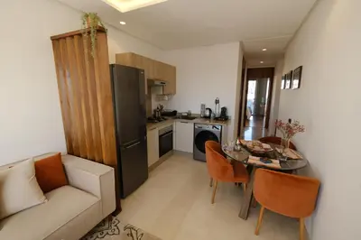 a kitchen with a couch and a table in a room at Appartement chic et cosy - Casablanca Finance City in Casablanca