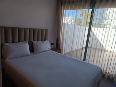 a bed with two pillows in a bedroom with a window at Signature Leving 119 in Casablanca