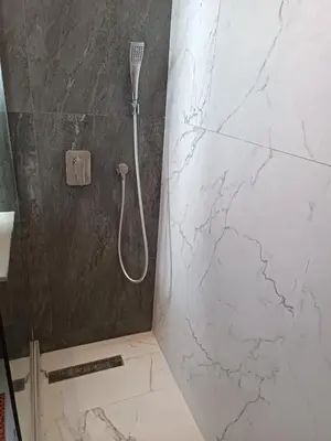 a bathroom with a shower with a marble wall at Signature Leving 119 in Casablanca