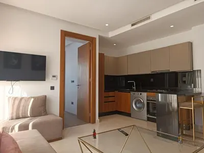 a living room with a couch and a kitchen at Signature Leving 119 in Casablanca
