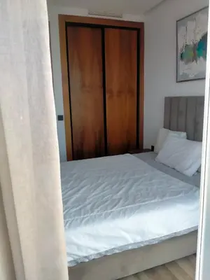 a bedroom with a bed with a wooden door at Signature Leving 119 in Casablanca