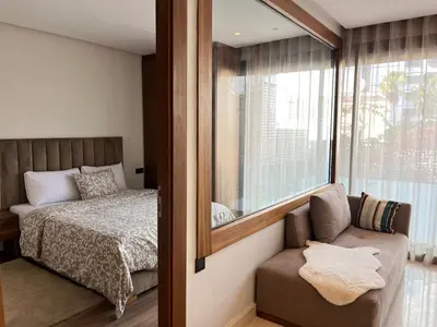 a bedroom with a bed and a mirror and a chair at Signature Leving 119 in Casablanca
