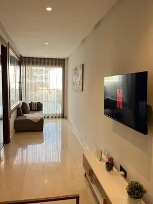 a living room with a couch and a television on a wall at Signature Leving 119 in Casablanca