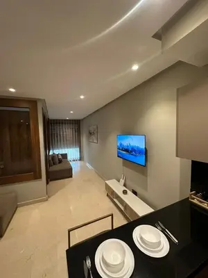 a kitchen and living room with a table and a television at Signature Leving 119 in Casablanca