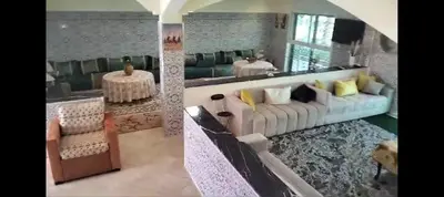 a living room with a white couch with yellow pillows at RiadNA bouznika in Bouznika