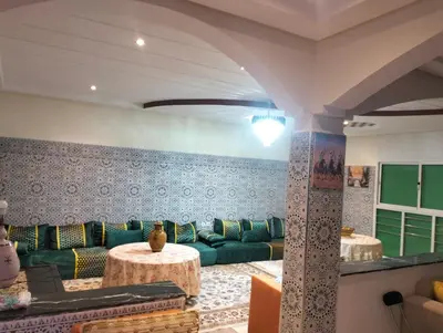 a living room with a green couch and a table at RiadNA bouznika in Bouznika