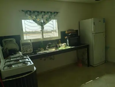 a kitchen with a stove and a sink and a refrigerator at RiadNA bouznika in Bouznika