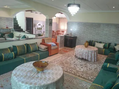 a living room with green couches and a table at RiadNA bouznika in Bouznika