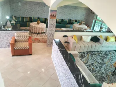 a living room with two couches and two tables at RiadNA bouznika in Bouznika