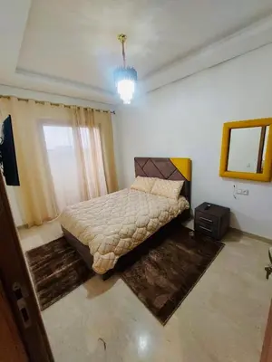 a bedroom with a bed and a mirror in it at Séjour serein près aéroport in Nouaceur
