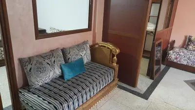 a couch with a blue pillow sitting in a room at Old school in Rabat