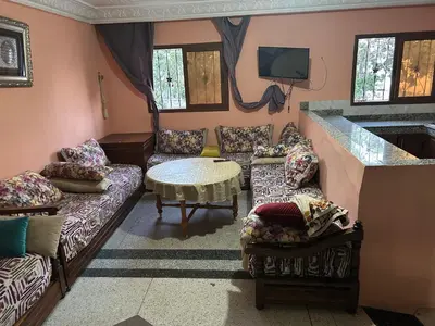 a living room with couches and a table and a tv at Old school in Rabat