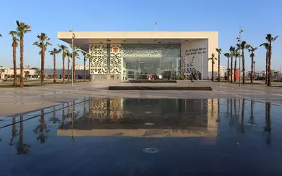 a large building with palm trees in front of it at Old school in Rabat