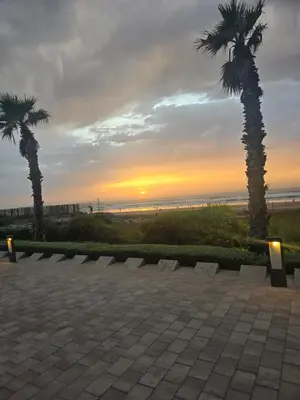 a sunset with two palm trees and the beach at AnfaPlace Residence, Casablanca, la Cornishe-Ain Diab in Casablanca