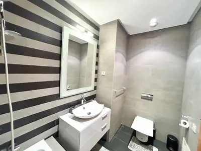 a bathroom with striped walls and a sink and a mirror at Luxury apartment Marina in Casablanca