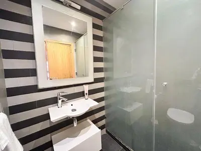 a bathroom with a sink and a glass shower at 2-bedroom apartment with a breathtaking sea view in Casablanca