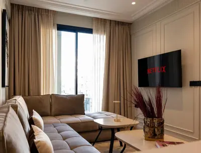 a living room with a couch and a tv at Cozy & Modern Apartment with Rooftop Gym Great Casablanca Location in Casablanca