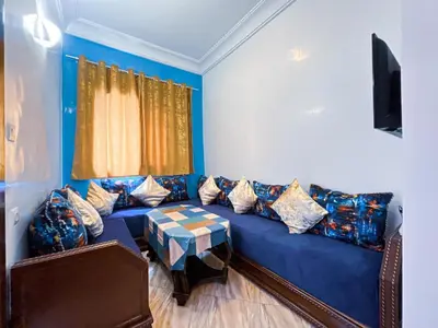 a living room with a blue couch and a table at Center Cozy Home in Casablanca