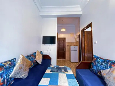 a living room with a blue couch with pillows at Center Cozy Home in Casablanca