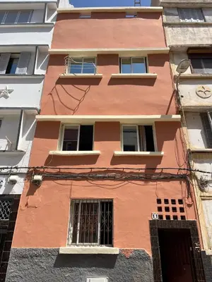 a tall orange building with windows at Center Cozy Home in Casablanca
