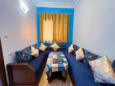 a living room with a blue couch with a table at Center Cozy Home in Casablanca