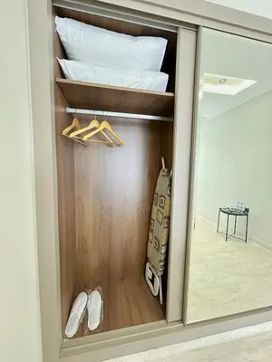 ajar door of a closet with a bed and shoes at Chic & Design Loft À 5 Minutes de la Corniche in Casablanca