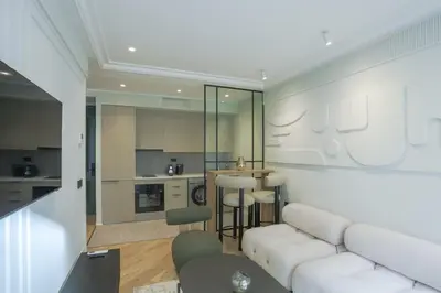 a living room with a white couch and a kitchen at Cosy cocon Racine in Casablanca