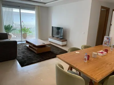 a living room with a table and a television at HM38 I Spacious & modern close to amenities in Casablanca