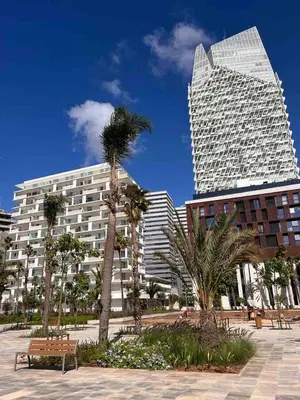 a tall building with palm trees in front of a bench at HM38 I Spacious & modern close to amenities in Casablanca