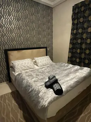 a bedroom with a bed with a remote control on it at Beachside Charming Apartment in Tamaris
