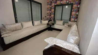 a living room with a couch and two windows at Beachside Charming Apartment in Tamaris