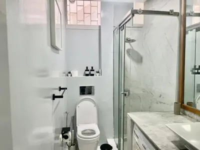 a white bathroom with a toilet and a shower at Charming 3 Bedroom Apt in Agdal in Rabat
