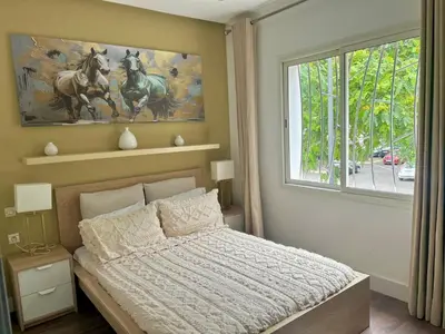 a bedroom with a bed and a large window at Charming 3 Bedroom Apt in Agdal in Rabat