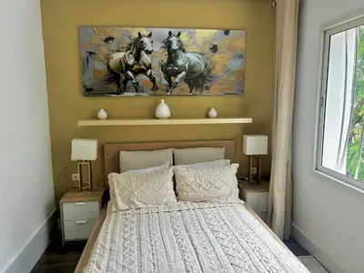 a bedroom with a bed and a painting of horses at Charming 3 Bedroom Apt in Agdal in Rabat