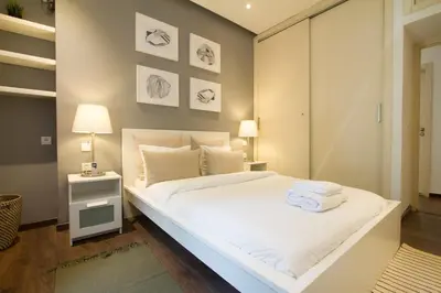 a bedroom with a large bed with white sheets at Charming 3 Bedroom Apt in Agdal in Rabat