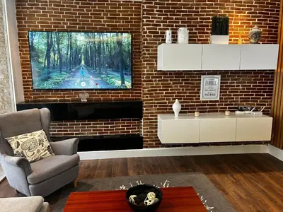 a living room with a tv on a brick wall at Charming 3 Bedroom Apt in Agdal in Rabat