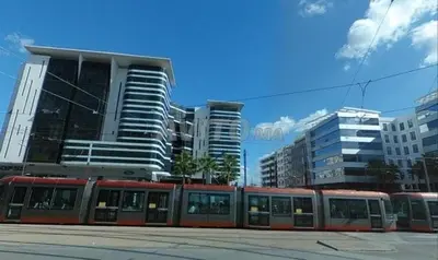 a train on a street in a city with buildings at Heart of Casablanca - Tramway in Casablanca