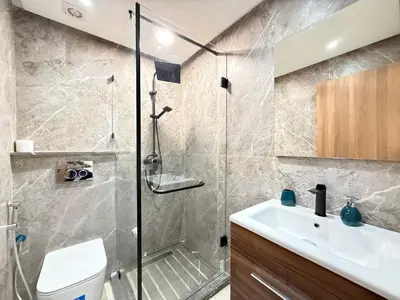 a bathroom with a shower and a toilet and a sink at Cosy Patio sunny 2BR - new building - near oasis train station in Casablanca