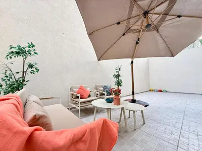 a living room with a couch and an umbrella at Cosy Patio sunny 2BR - new building - near oasis train station in Casablanca