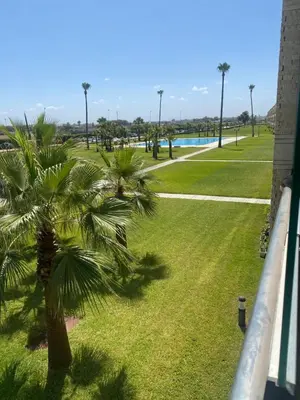 a view of a park with palm trees and a pool at Ola Blanca 2 in Tamaris