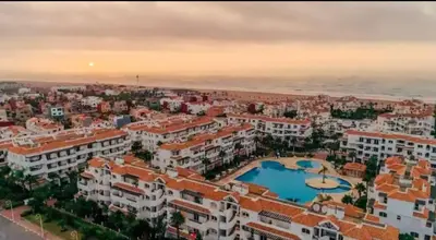 an aerial view of a city with buildings and a pool at Appartement moderne bord de mer in Sidi Rahal