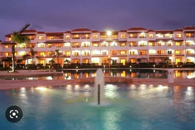 a large building with a fountain in front of it at Appartement moderne bord de mer in Sidi Rahal