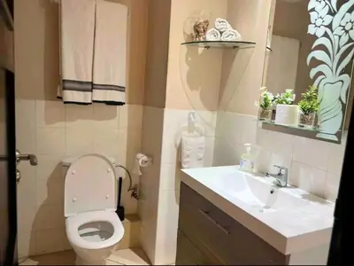 a bathroom with a toilet and a sink at Appartement moderne bord de mer in Sidi Rahal