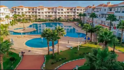 an aerial view of a resort with a pool and palm trees at Appartement moderne bord de mer in Sidi Rahal