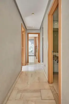an empty hallway with wooden doors and a tile floor at Luxury 3 Bedroom Getaway in Bouskouras Finest in Bouskoura