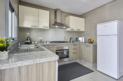 a kitchen with white appliances and a white refrigerator at Family-Friendly 3BR with Garden and Outdoor Space in Bouskoura