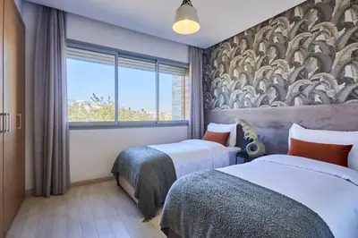 a hotel room with two beds and a window at Family-Friendly 3BR with Garden and Outdoor Space in Bouskoura