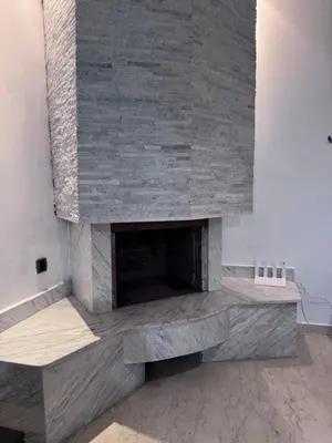 a living room with a stone fireplace at Appartement à Rabat in Rabat
